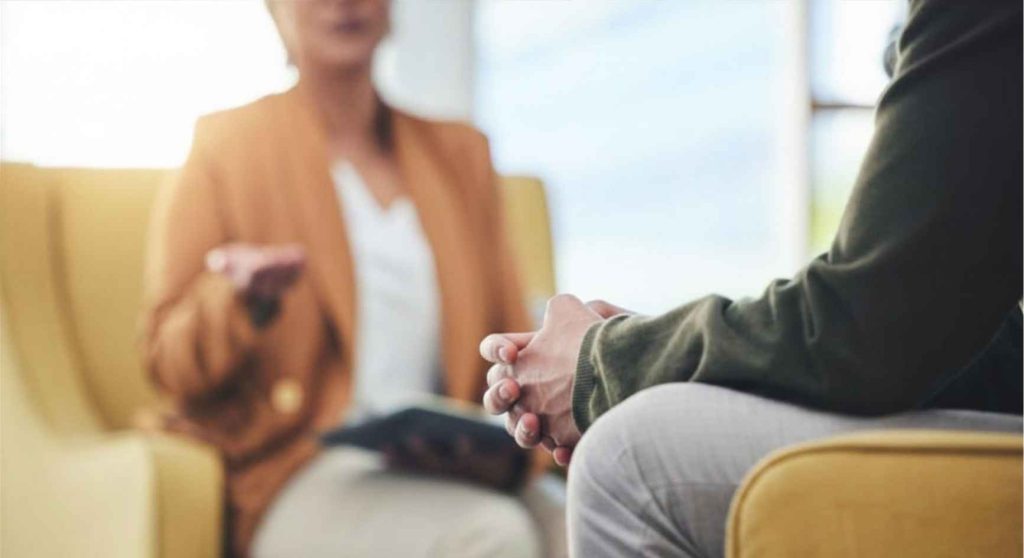 Client seated across from a counselor during a porn addiction coaching session