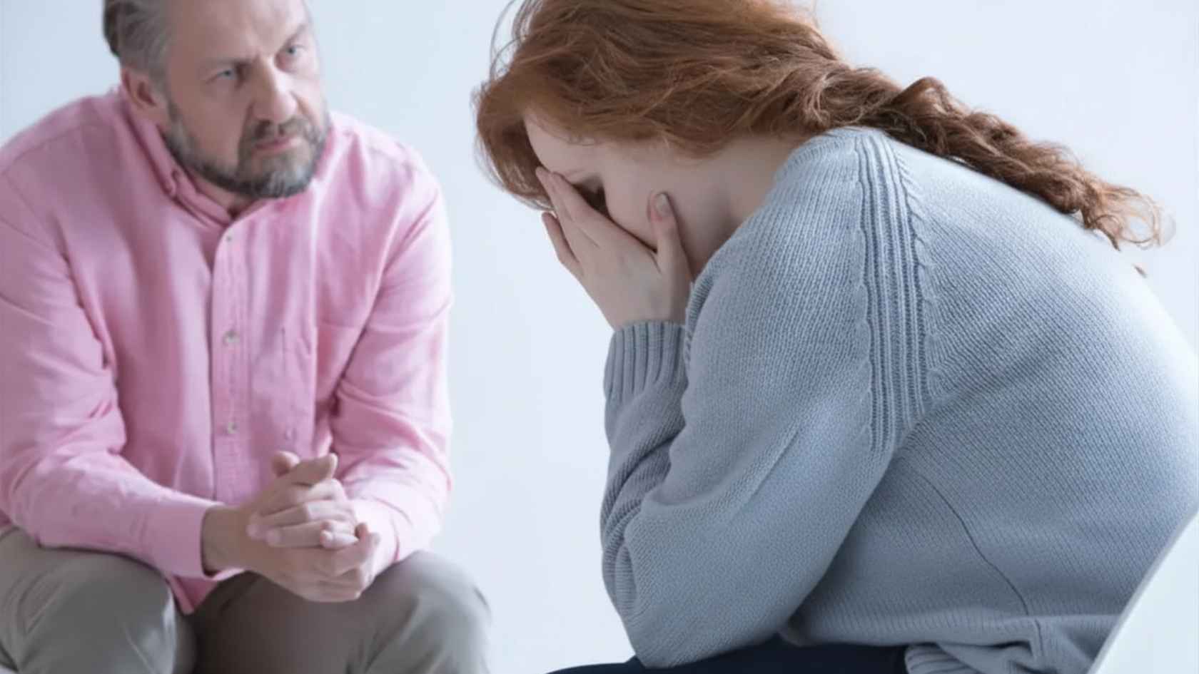 Woman covering her face while speaking with a counselor during sex addiction therapy