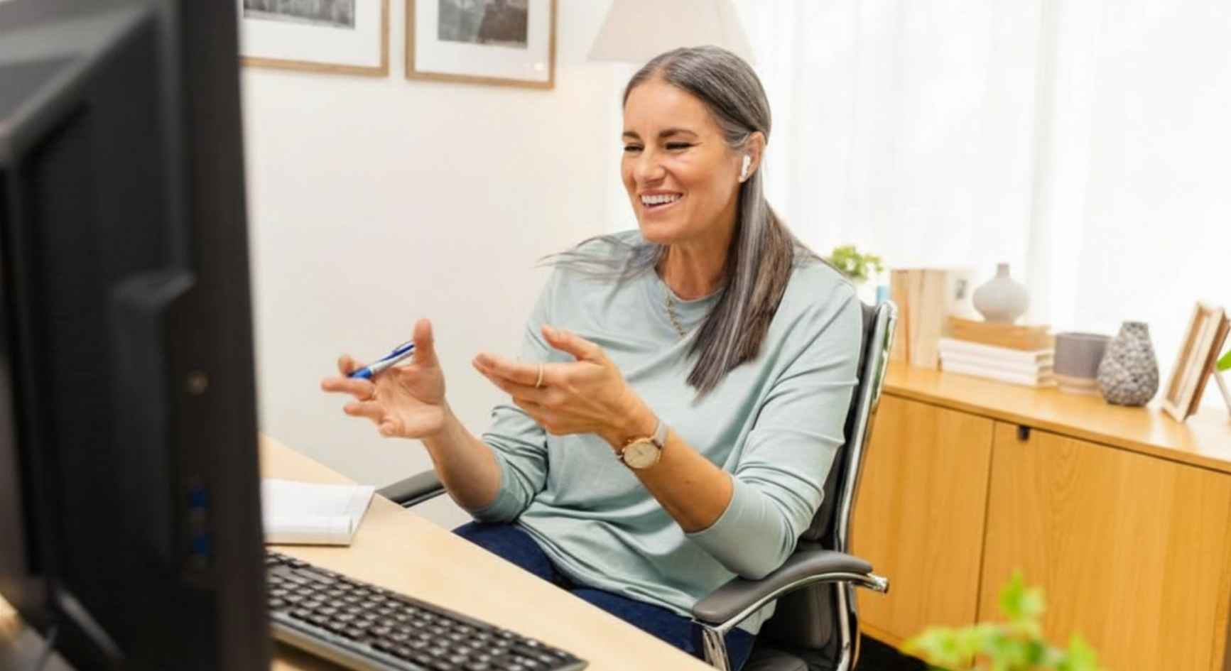 Female therapist gesturing during online mental health coaching session at desk