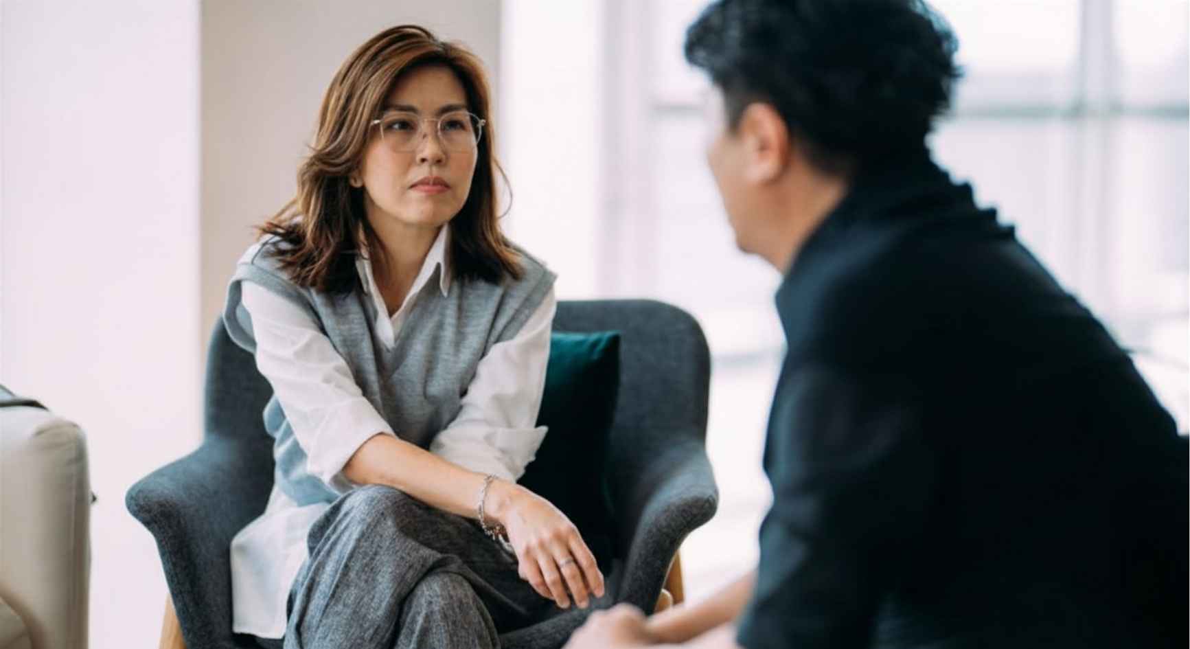Female therapist listening attentively to a male client during a coaching session