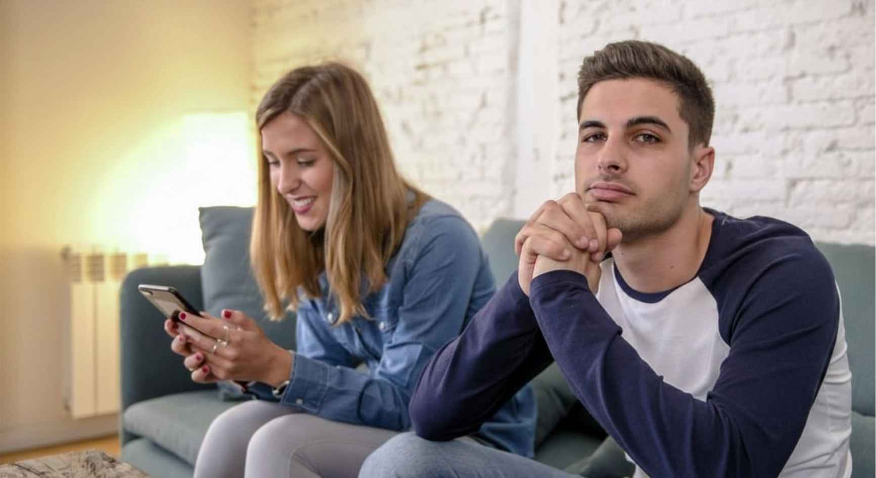 Woman absorbed in her phone beside a disengaged partner showing the need for social media addiction treatment