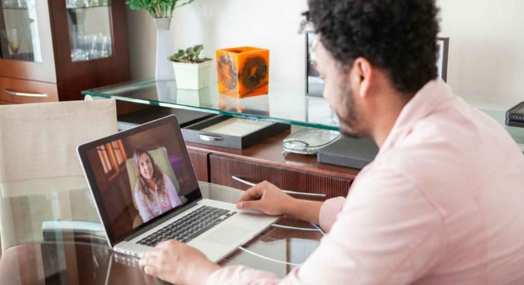 Man on laptop video call with female therapist during online mental health coaching session