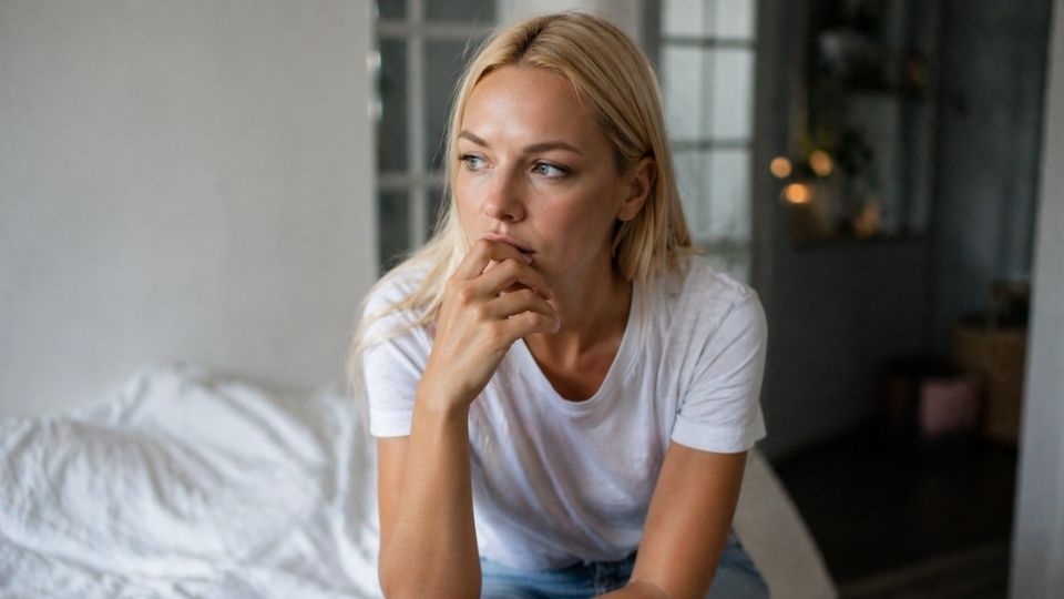 Recovery Coach vs. Therapist Do You Need One, the Other, or Both hero image of a woman thinking about the difference.
