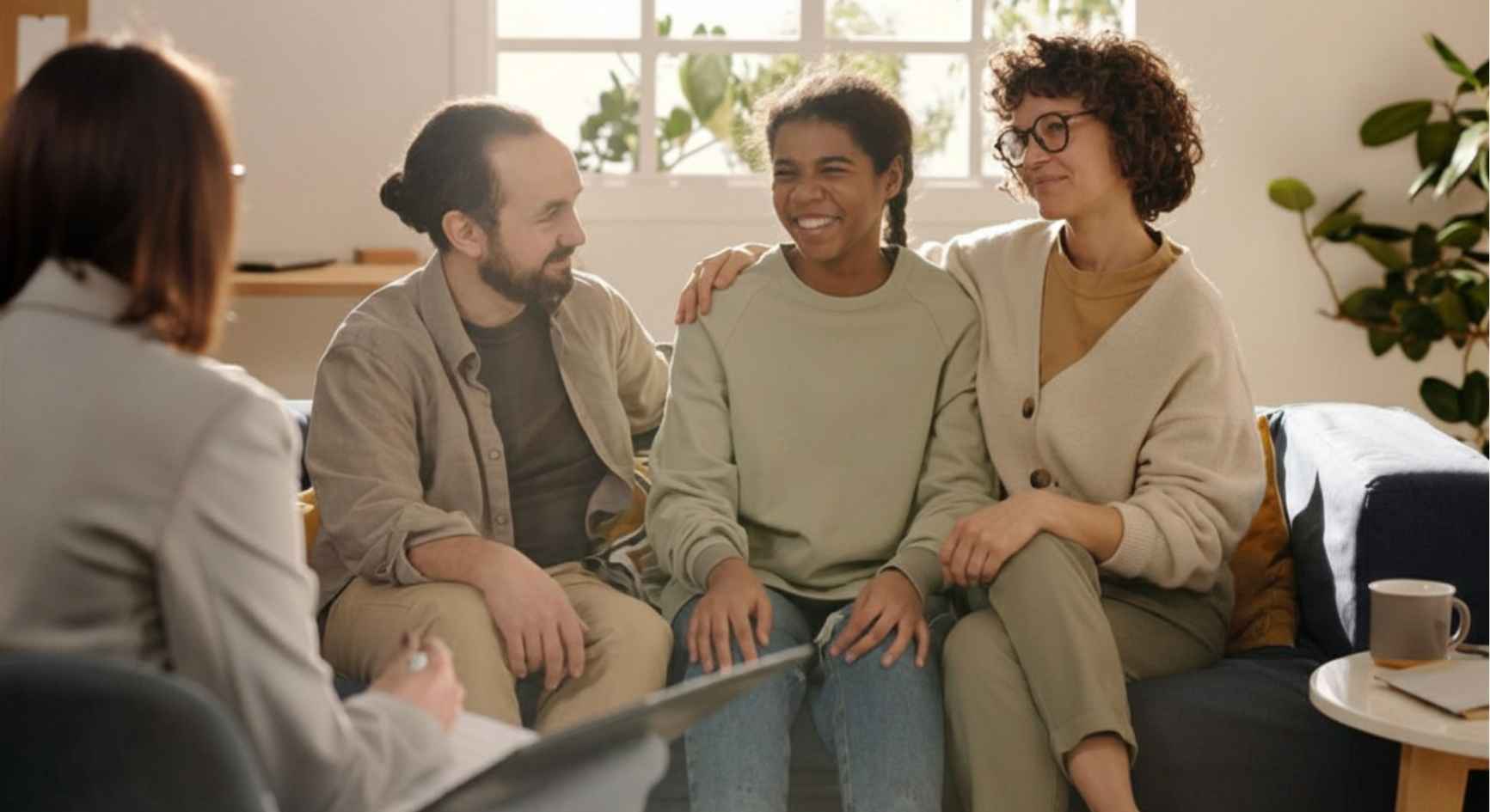 Smiling family with teenage daughter during a therapy session with a counselor