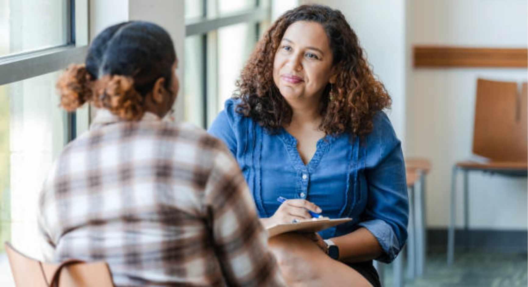 Smiling female counselor listening to a client during a therapy session
