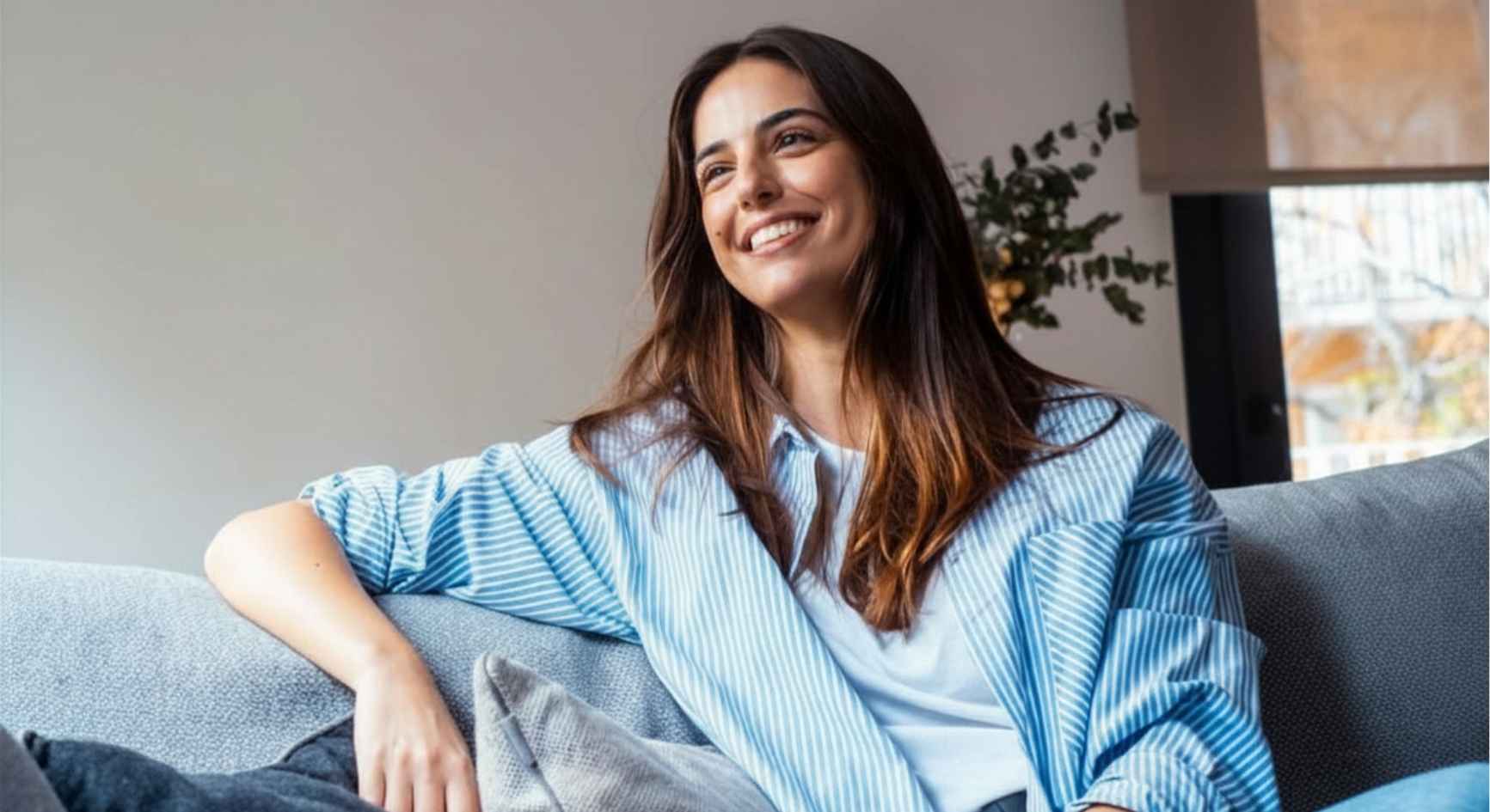Smiling young woman relaxing on a couch at home