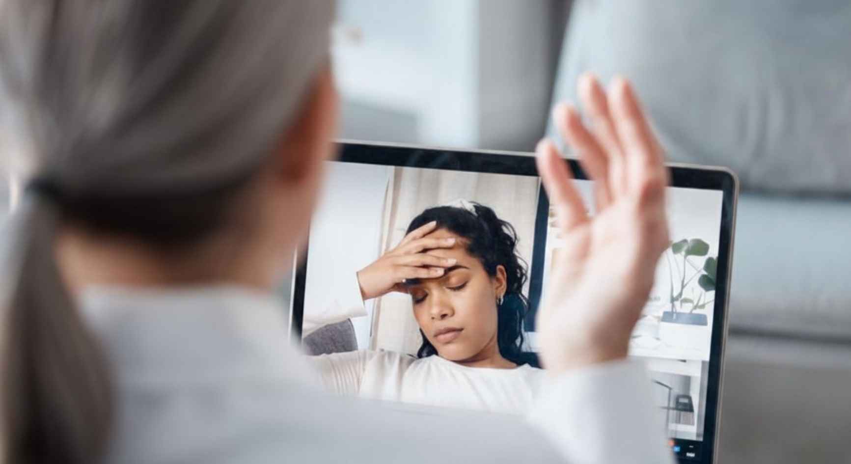 Therapist on video call with distressed woman during online mental health counseling session