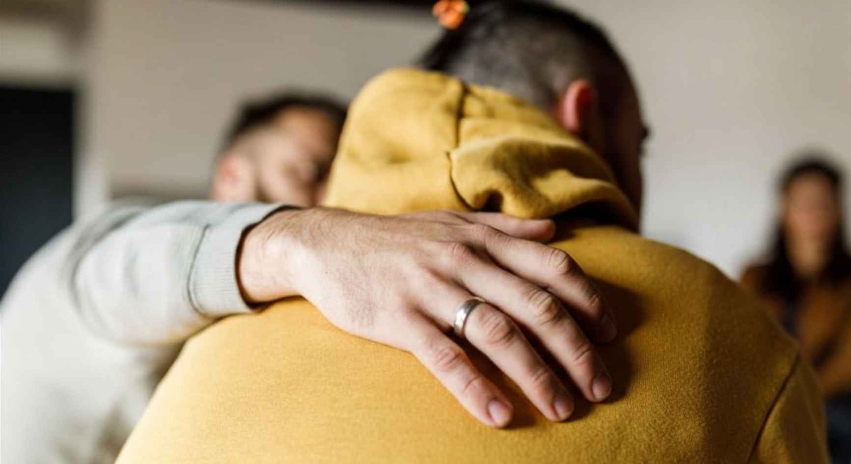 Two people embracing in a supportive hug during an addiction counseling session