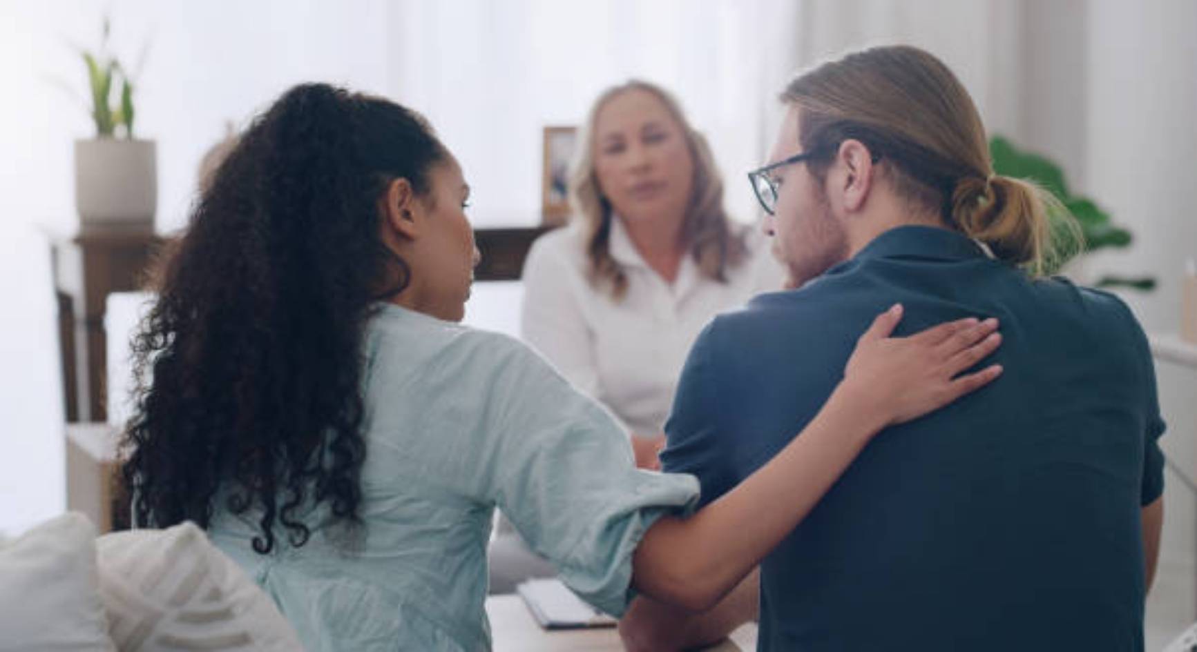 Woman comforting her partner during a couples coaching session with a female therapist
